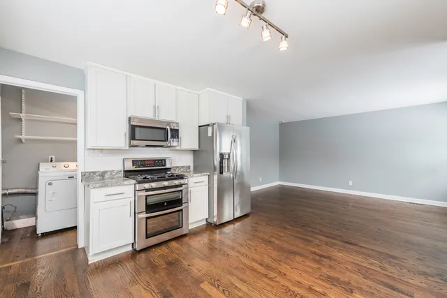 a kitchen with a sink stainless steel appliances and white cabinets