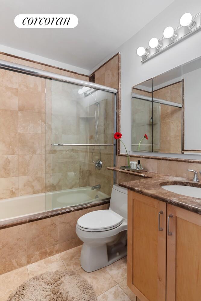 137 East 36th Street, Unit 3G Manhattan, NY 10016 - Photo 9 of 14 a bathroom with a granite countertop sink mirror toilet and shower