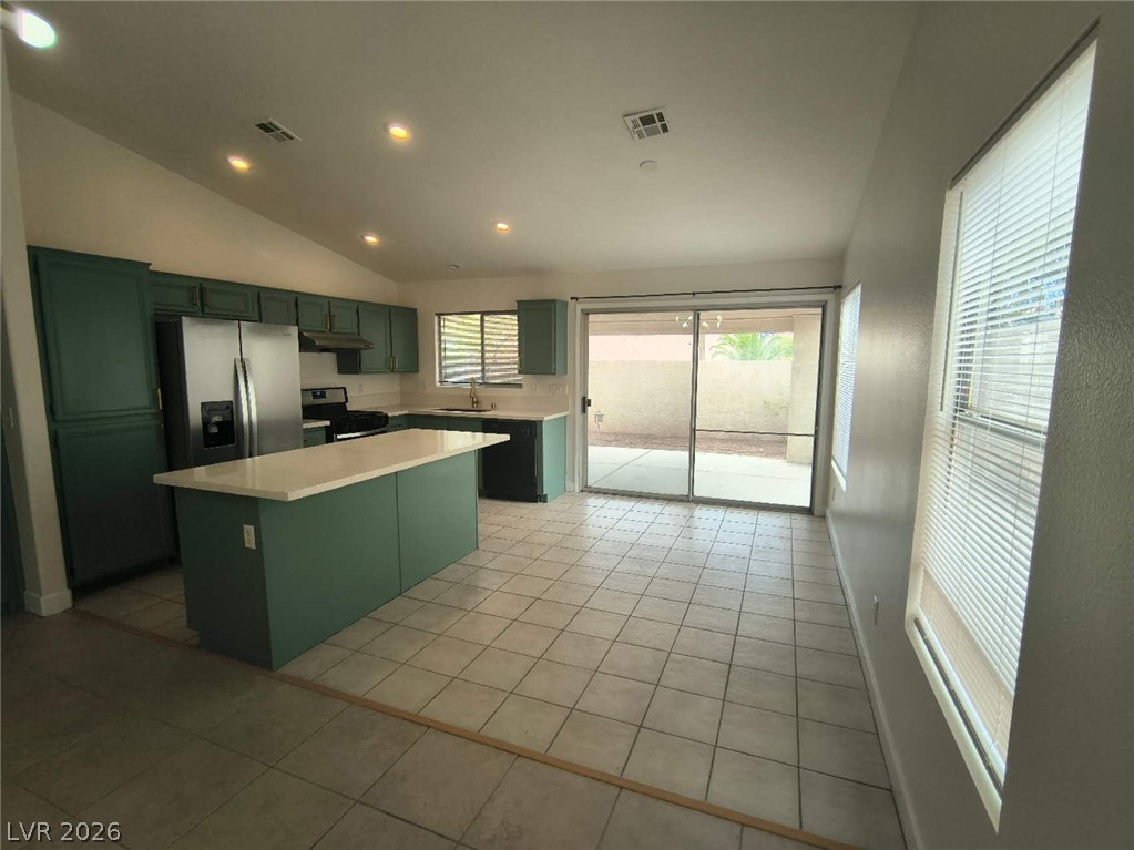 9725 Pima Point Avenue Las Vegas, NV 89147 - Photo 9 of 35 A well-equipped kitchen features a central island, recessed lighting, and direct patio access.