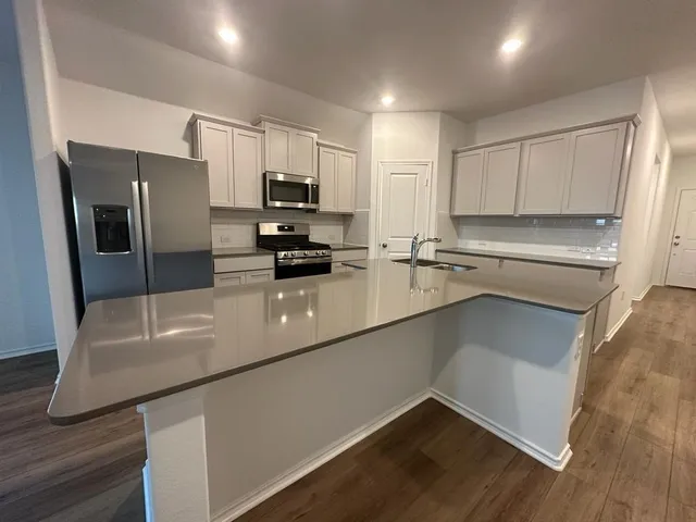 a kitchen with stainless steel appliances a refrigerator sink and microwave