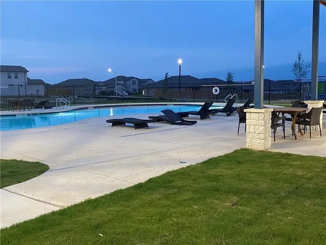 a view of swimming pool with outdoor seating and lake view