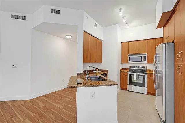 a kitchen with stainless steel appliances a refrigerator stove and sink