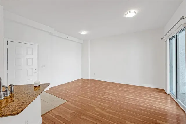 a view of a livingroom with wooden floor and bedroom