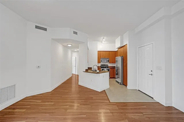 a view of kitchen with wooden floor and electronic appliances