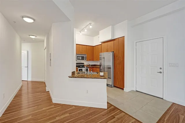 a view of a kitchen with refrigerator and wooden floor