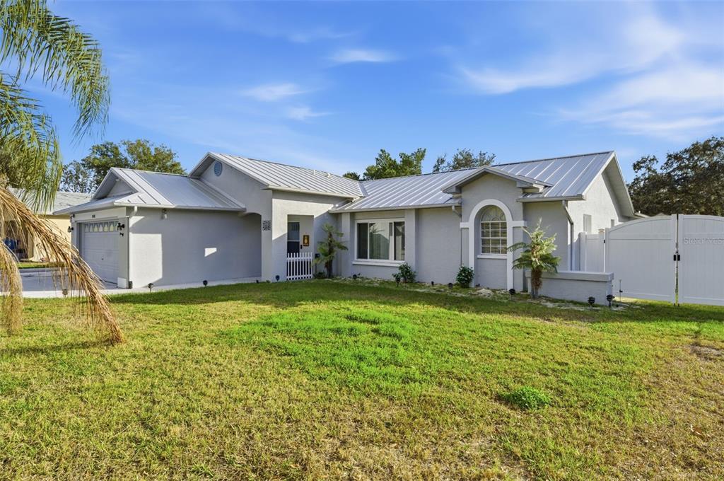10448 Utah Street Spring Hill, FL 34608 - Photo 12 of 54 a front view of a house with a garden and yard