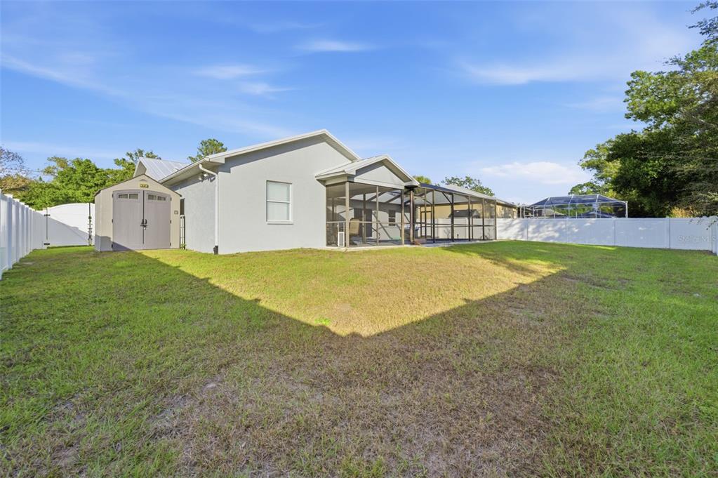 10448 Utah Street Spring Hill, FL 34608 - Photo 20 of 54 a view of a house with a big yard and large trees