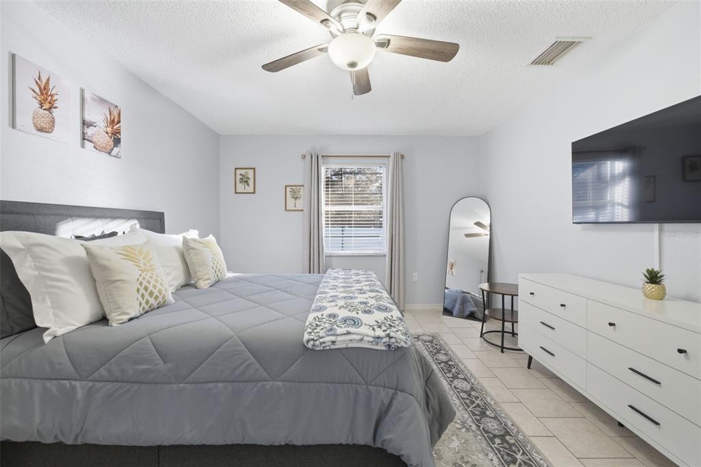 10448 Utah Street Spring Hill, FL 34608 - Photo 48 of 54 a bedroom with a large bed and a flat tv screen on dresser