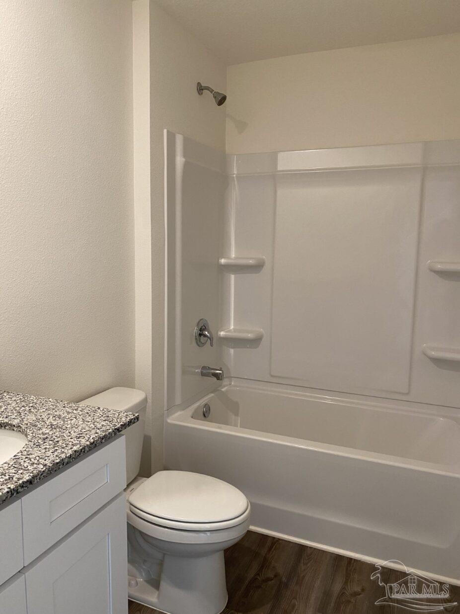 9252 3 Hollow Road Jay, FL 32565 - Photo 9 of 18 a bathroom with a granite countertop toilet and a bathtub