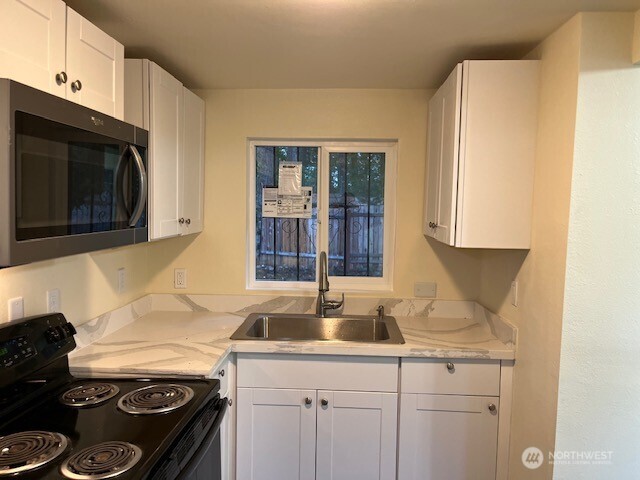 12524 Addison Street Southwest Lakewood, WA 98499 - Photo 8 of 17 a kitchen with granite countertop a sink stove and cabinets