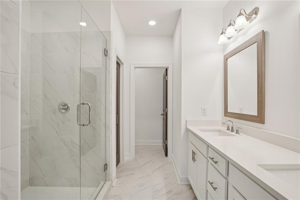 653 Silva Street, Unit 139 Cumming, GA 30040 - Photo 27 of 47 a bathroom with a double vanity sink mirror and shower