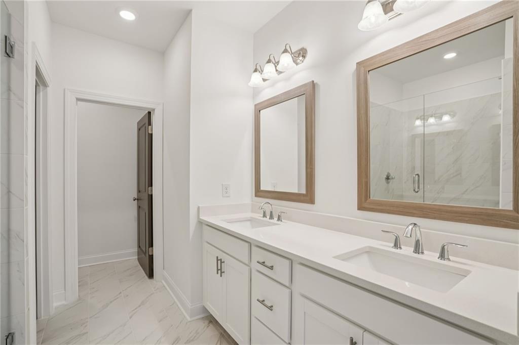 653 Silva Street, Unit 139 Cumming, GA 30040 - Photo 28 of 47 a bathroom with double vanity sinks and a mirror