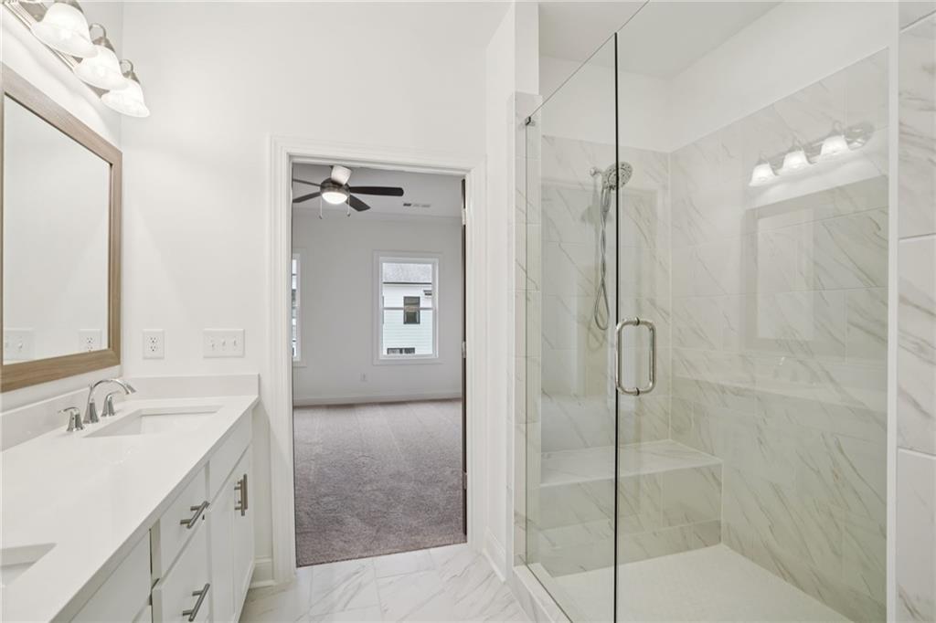 653 Silva Street, Unit 139 Cumming, GA 30040 - Photo 30 of 47 a bathroom with a shower sink and mirror