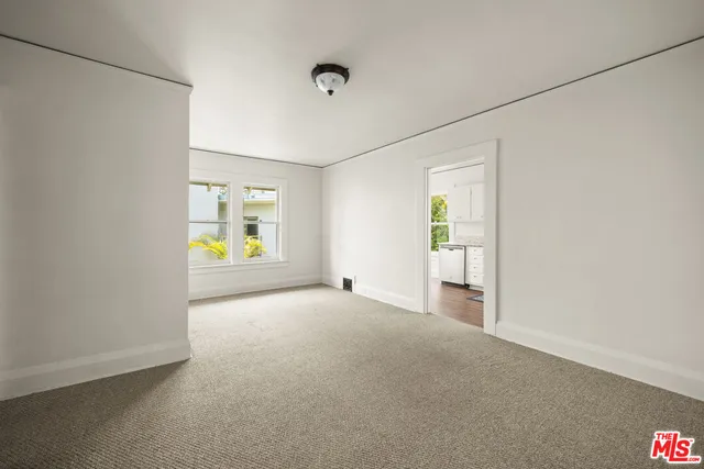 an empty room with windows and mirror