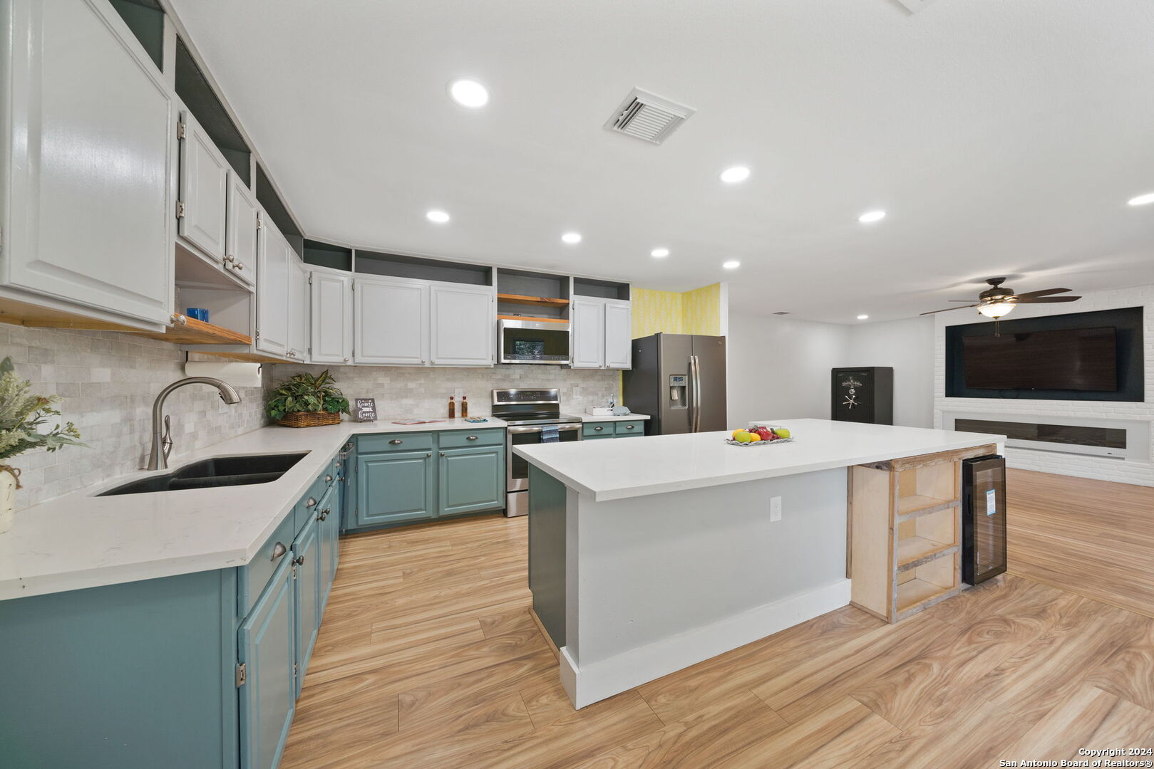 a kitchen with kitchen island stainless steel appliances a sink a stove a microwave a center island and some cabinets