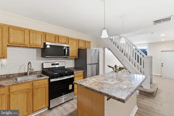 a kitchen with a stove a sink dishwasher and a microwave