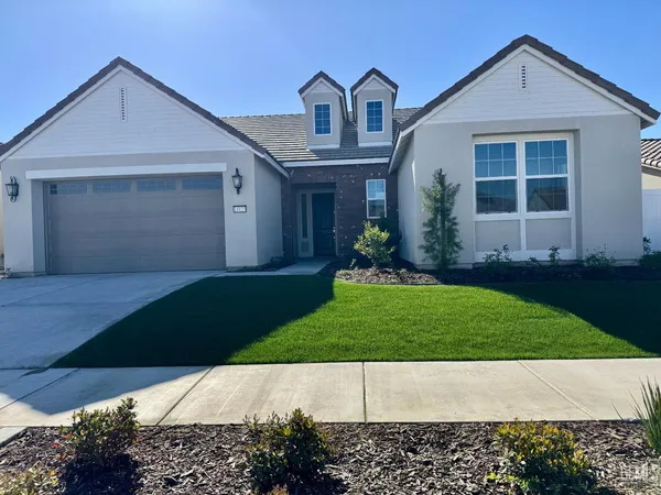 a front view of a house with a garden and yard