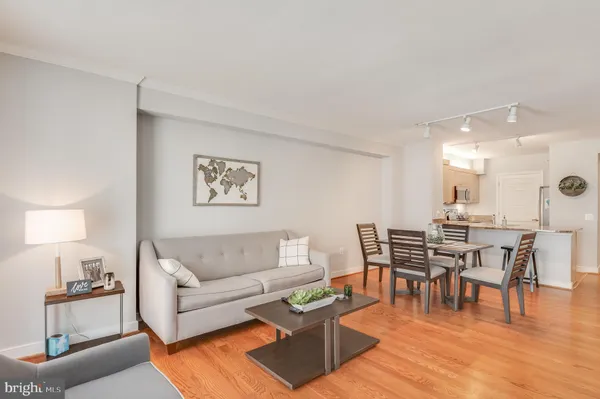 a living room with furniture a dining table and a piano table with wooden floor