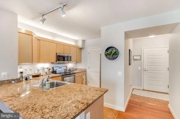 a kitchen with granite countertop a refrigerator and a stove top oven