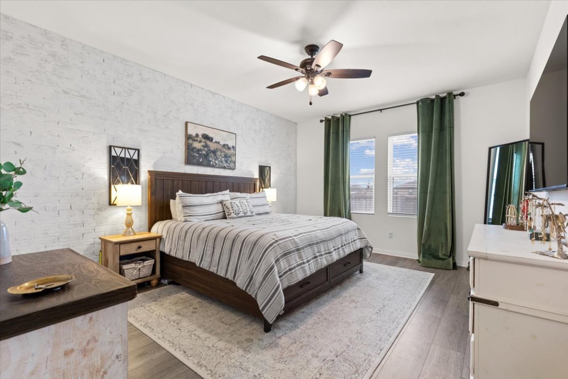 19305 Nathan Scott Way Manor, TX 78653 - Photo 9 of 18 a spacious bedroom with a bed and a chandelier