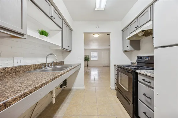 a kitchen with stainless steel appliances granite countertop a sink and a stove