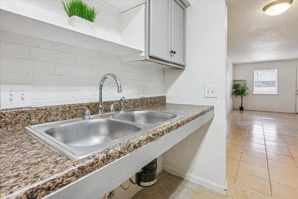 a kitchen with granite countertop a sink and a wooden floor