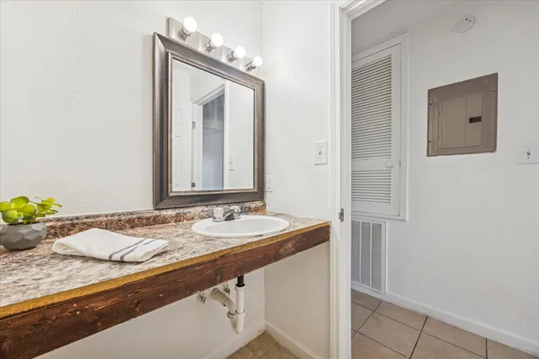 a bathroom with a granite countertop sink and a mirror