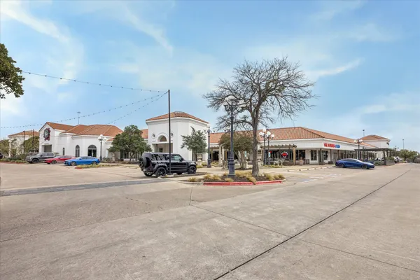 a front view of a building with streets and trees