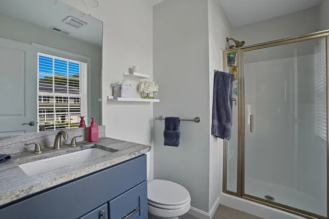 a bathroom with a granite countertop sink toilet and shower