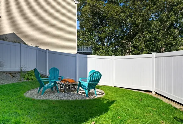 a view of a chair and table in backyard of the house
