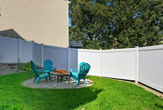 a view of a chair and table in backyard of the house