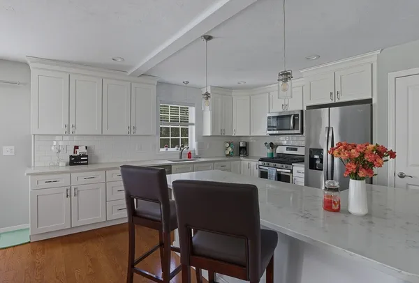 a kitchen with stainless steel appliances granite countertop a white cabinets and a stove top oven
