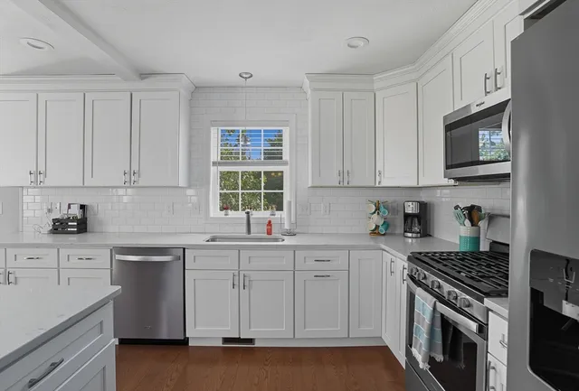 a kitchen with stainless steel appliances granite countertop a stove a sink and a microwave