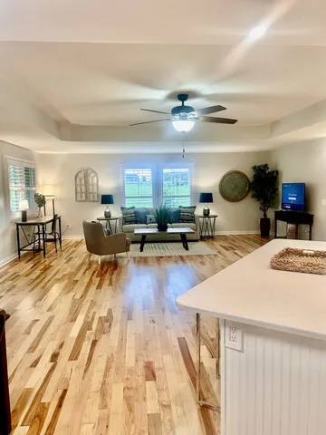 a living room with lots of furniture and kitchen view
