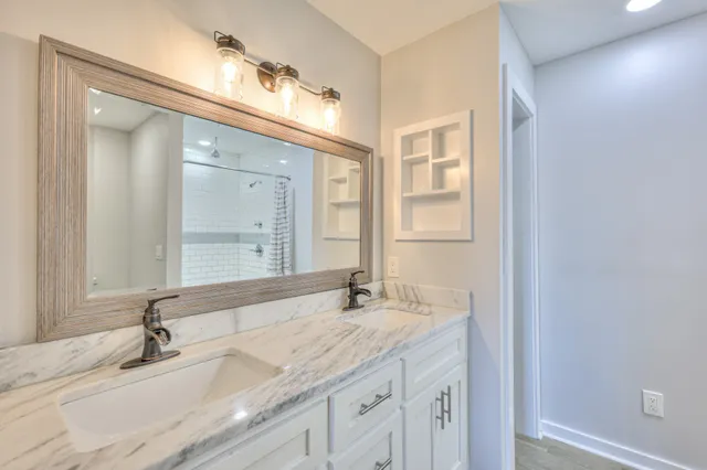 a bathroom with a granite countertop double vanity sink and a mirror