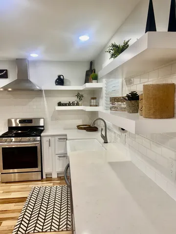 a kitchen with stainless steel appliances granite countertop a stove and a sink