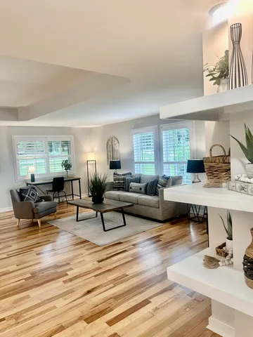 a living room with furniture and a wooden floor