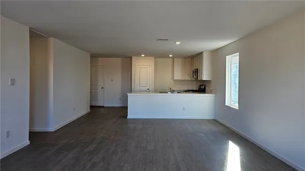 a view of kitchen with center island wooden floor and electronic appliances
