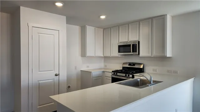 a kitchen with a sink a microwave and cabinets