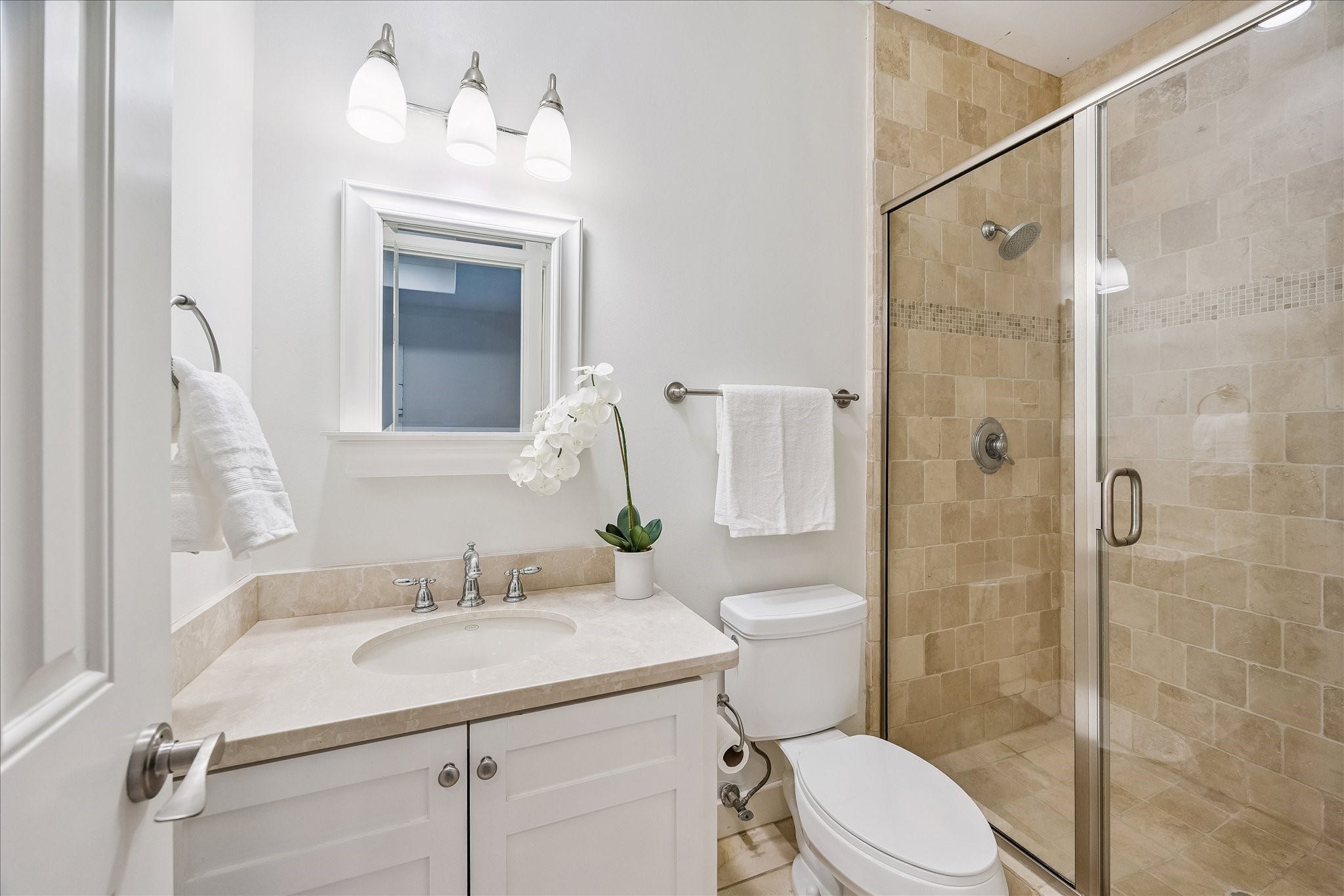 4010 Milton Street Houston, TX 77005 - Photo 25 of 49 BATHROOM TWO. Travertine finishes and a glass-enclosed shower elevate this secondary bathroom.