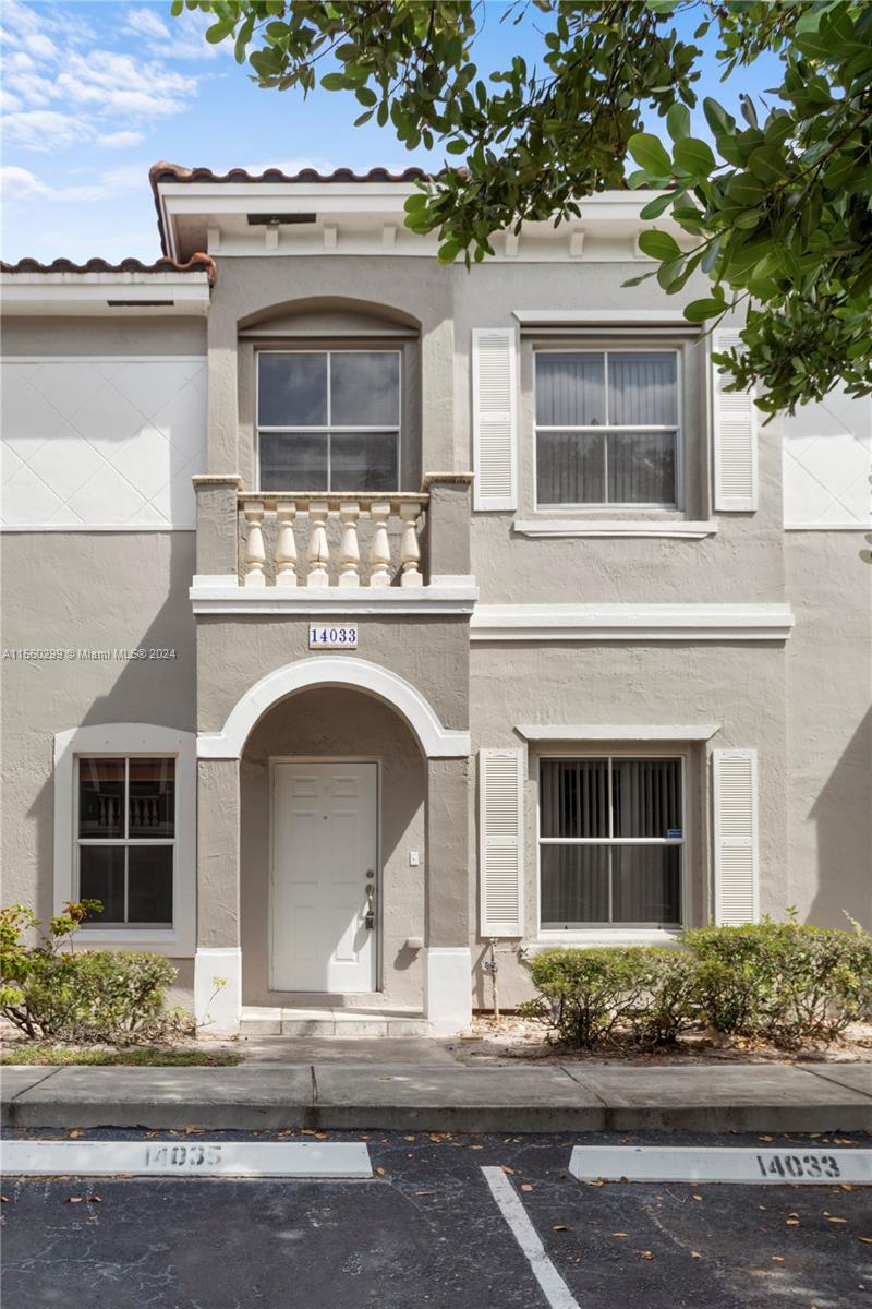 14033 Southwest 49th Street, Unit 6 Miramar, FL 33027 - Photo 2 of 25 a front view of a house with a garden