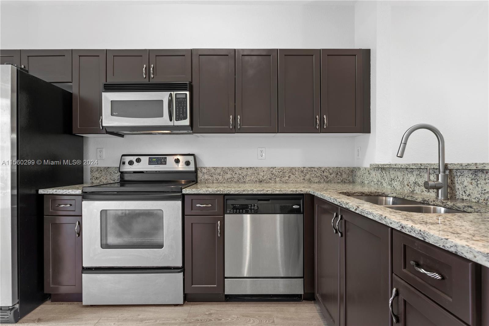 14033 Southwest 49th Street, Unit 6 Miramar, FL 33027 - Photo 4 of 25 a kitchen with granite countertop a stove and a sink