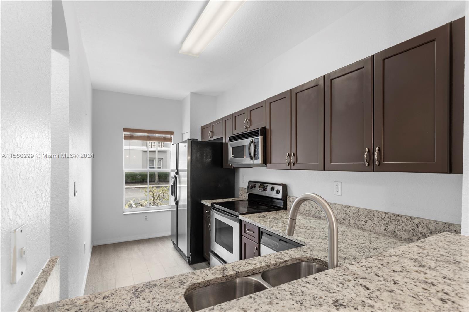 14033 Southwest 49th Street, Unit 6 Miramar, FL 33027 - Photo 6 of 25 a kitchen with stainless steel appliances granite countertop a refrigerator and a sink