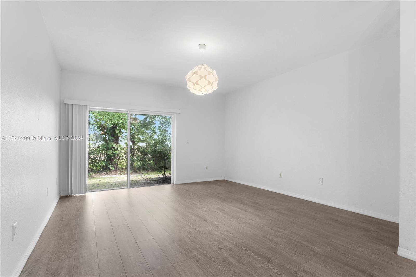 14033 Southwest 49th Street, Unit 6 Miramar, FL 33027 - Photo 9 of 25 an empty room with wooden floor and windows