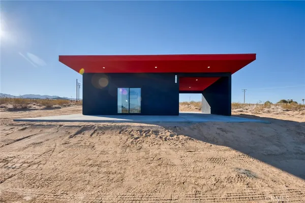 a view of a room with a bed and wooden floor