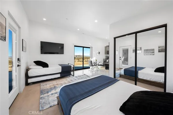 a bedroom with a bed a couch and a flat screen tv