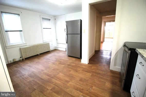 a view of a kitchen with furniture and a refrigerator