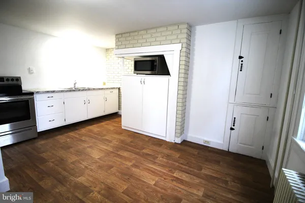 a kitchen with granite countertop white cabinets and white appliances