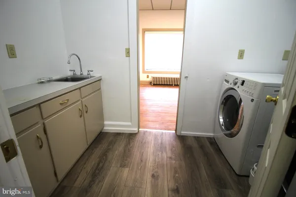 a utility room with wooden floor washer and dryer