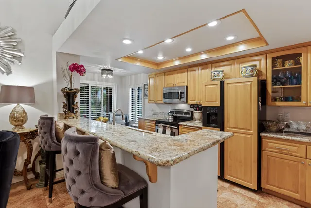 a kitchen with sink refrigerator dining table and chairs